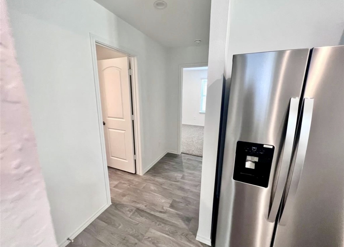14220 Fern Meadows Drive Splendora, TX 77372 - Photo 11 of 22 a view of a refrigerator in kitchen and an empty room