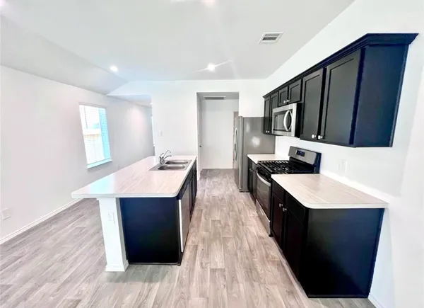 a kitchen with a sink a counter top space and appliances