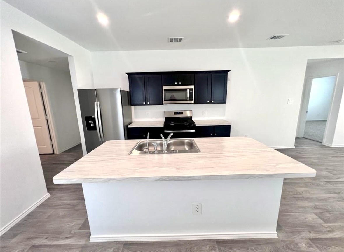 14220 Fern Meadows Drive Splendora, TX 77372 - Photo 7 of 22 a room with stainless steel appliances kitchen island sink refrigerator and stove