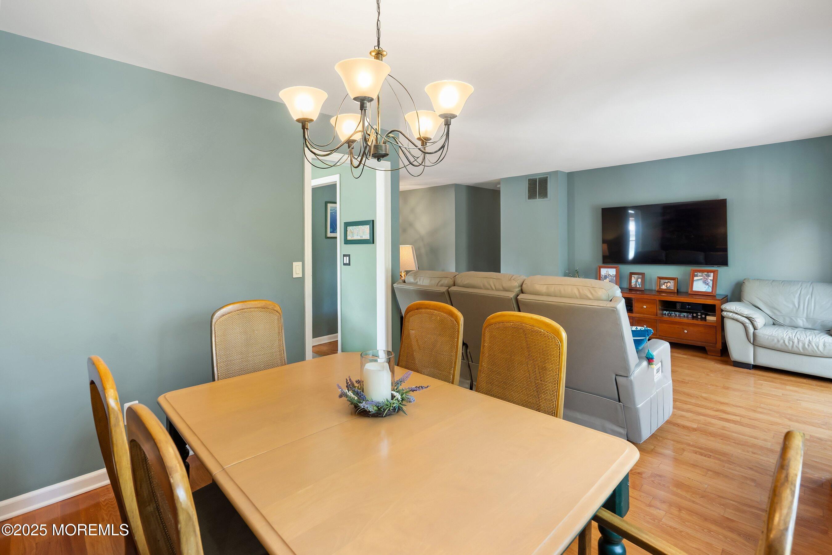 10 Cove Court Howell, NJ 07731 - Photo 11 of 40 a view of a dining room with furniture a chandelier and wooden floor