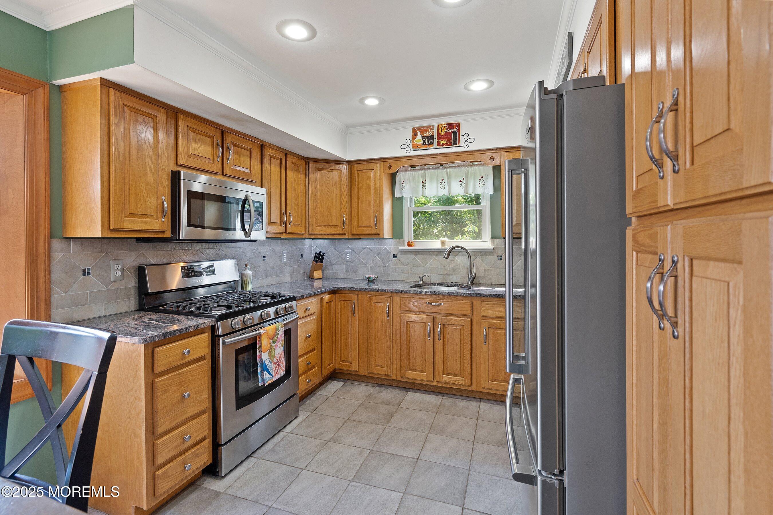 10 Cove Court Howell, NJ 07731 - Photo 16 of 40 a kitchen with stainless steel appliances granite countertop a refrigerator a stove a sink and a microwave
