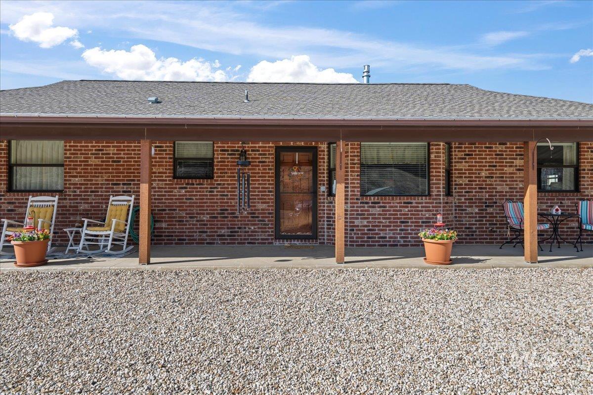 10514 Airpark Loop Road Melba, ID 83641 - Photo 5 of 50 Rear view of house with roof with shingles, brick siding, and a patio area