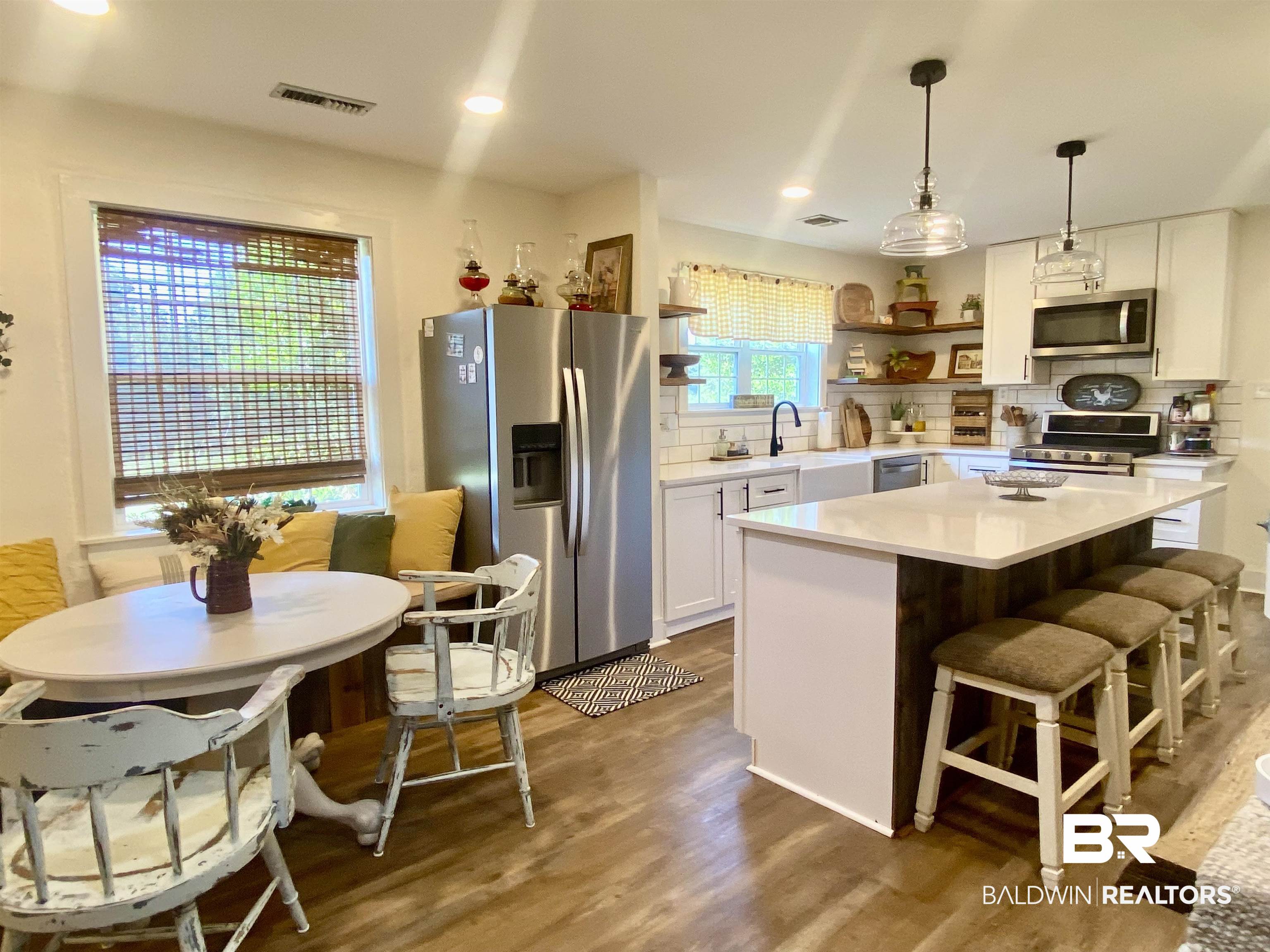 531 Highway 136 Monroeville, AL 36460 - Photo 17 of 48 Kitchen with white cabinetry, hardwood / wood-style flooring, backsplash, and stainless steel appliances