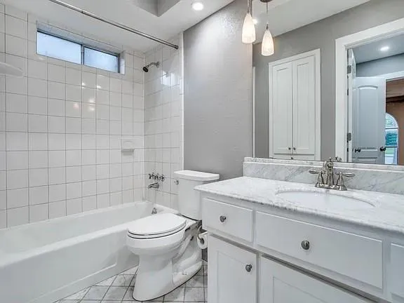 a bathroom with a granite countertop sink toilet a large mirror a bathtub and shower