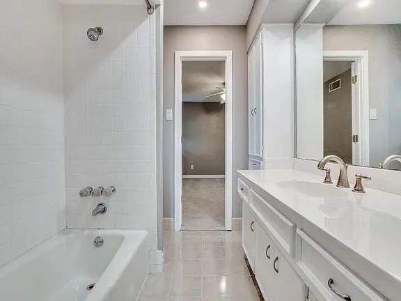 a bathroom with a bathtub sink and mirror