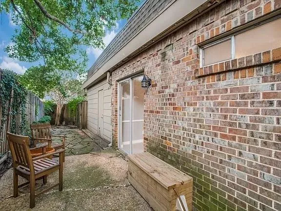 a view of patio with a table and chairs and wooden fence