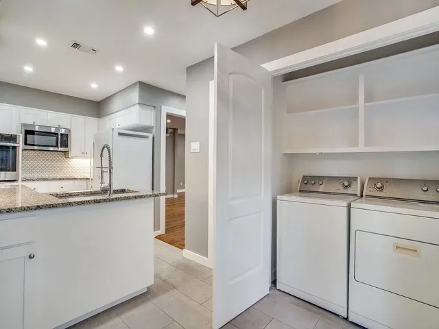 a kitchen that has a lot of white cabinets