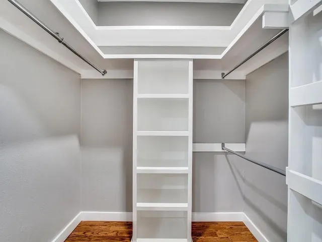 a view of walk in closet with empty racks