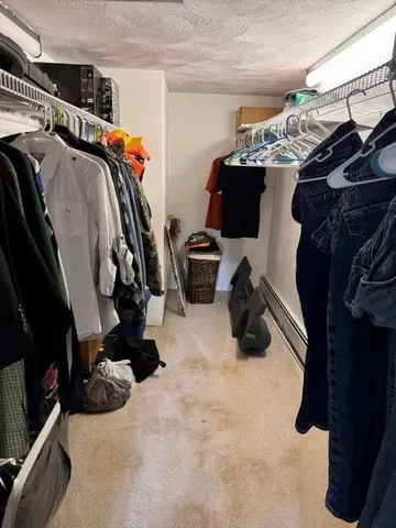 a view of walk in closet with clothes and shoes