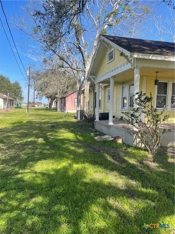 a view of a house with a big yard and sitting area