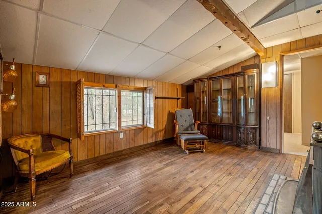 a view of a hallway with wooden floor and a bathroom
