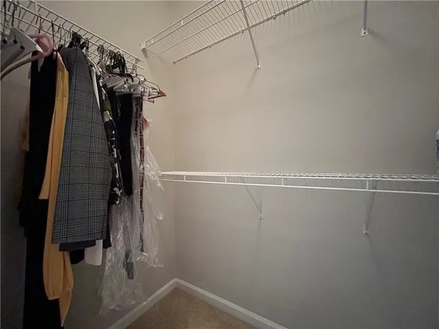a view of walk in closet with clothes