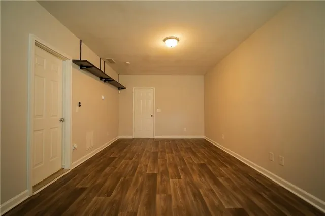 a view of a room with wooden floor and white walls