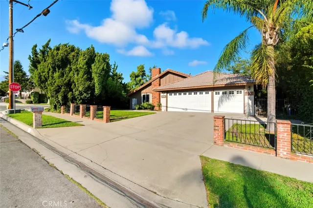 a view of a house with a yard and potted plants
