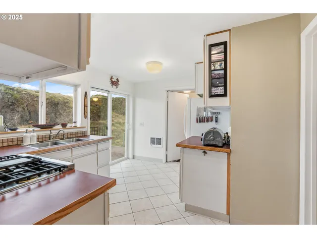a kitchen with stainless steel appliances a stove a refrigerator and a dining table