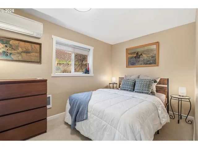 a bedroom with a bed and a painting on the wall