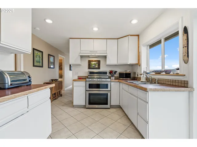 a kitchen with stainless steel appliances granite countertop a stove a sink and a refrigerator