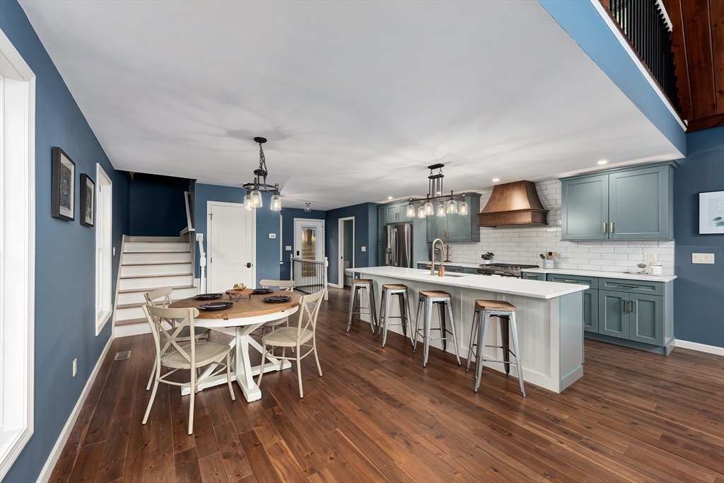 108 Stiles Pond Road Boxford, MA 01921 - Photo 10 of 38 a kitchen with stainless steel appliances a kitchen island hardwood floor sink stove dining table and chairs