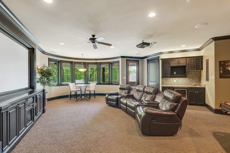 336 Pisgah Road Eads, TN 38028 - Photo 18 of 25 Incredible room with Berber carpet, blackout window screens, sconce lighting, projector system with screen encased in a custom woodwork frame, wet bar with unpolished granite top, sink, cooler, surround sound, and door to large balcony.