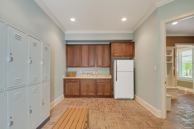 336 Pisgah Road Eads, TN 38028 - Photo 19 of 25 Awesome multi purpose room with exterior back door, towel rack & lockers, farm sink, Corian tops, cabinetry, & brick flooring-perfect for pool guests, pets, or party prep. Around the corner is a super chic full bath & bead board wall with hooks & bench.