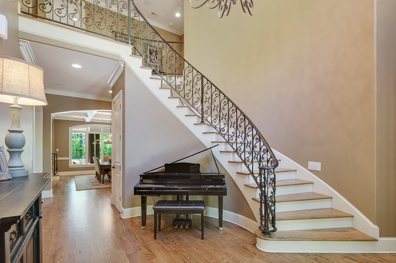 336 Pisgah Road Eads, TN 38028 - Photo 3 of 25 Stunning two story foyer with Tuscan doors, retractable chandelier, and grand curved staircase with wood treads and iron railing.