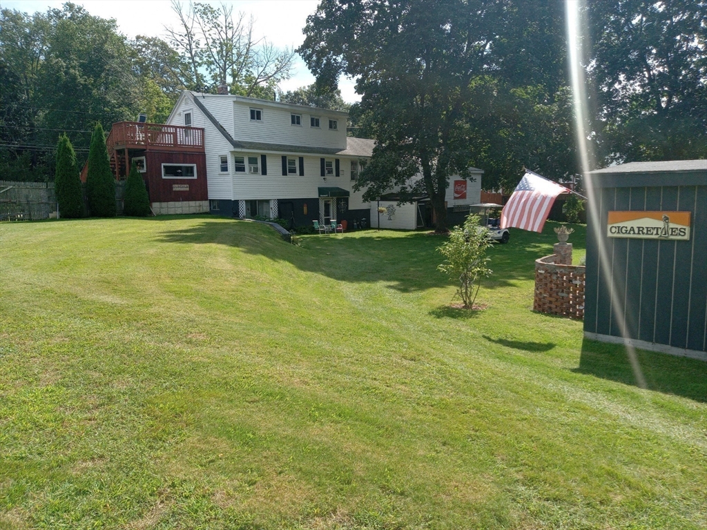 282 Central Street, Unit 1 Auburn, MA 01501 - Photo 5 of 16 a front view of house with yard and trees in the background