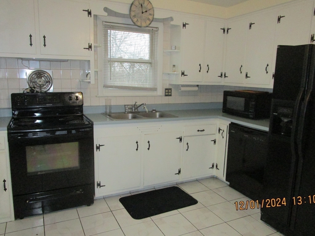 282 Central Street, Unit 1 Auburn, MA 01501 - Photo 9 of 16 a kitchen with granite countertop a stove and a microwave