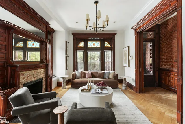 a living room with furniture a fireplace and a chandelier