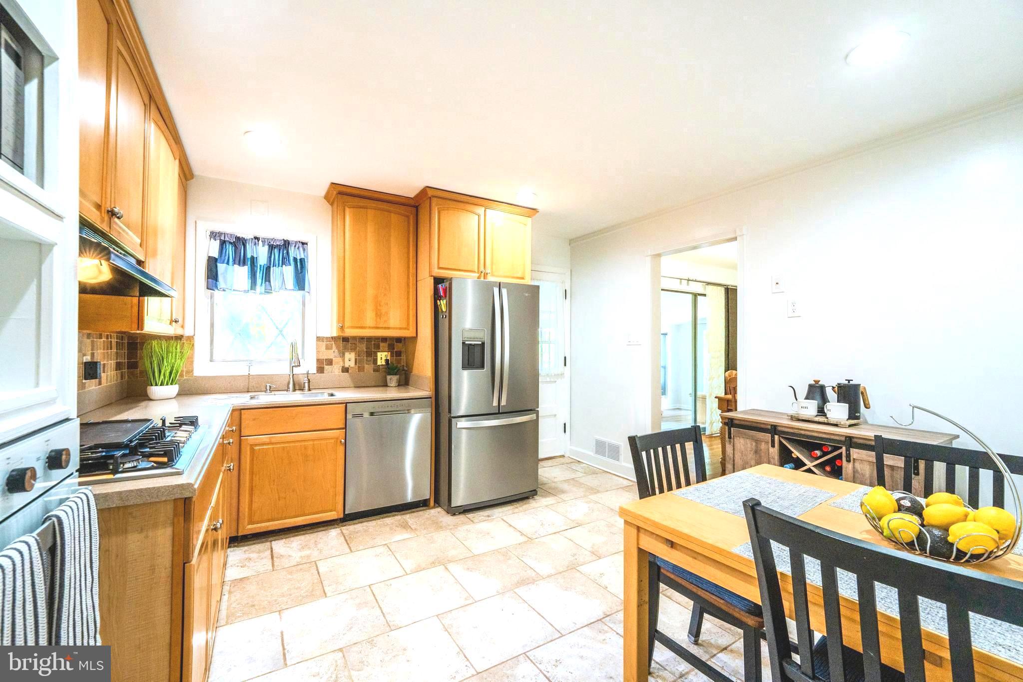 6705 Bracken Court Springfield, VA 22152 - Photo 12 of 40 a kitchen with stainless steel appliances kitchen island granite countertop a refrigerator a stove a sink and dishwasher a dining table with wooden floor