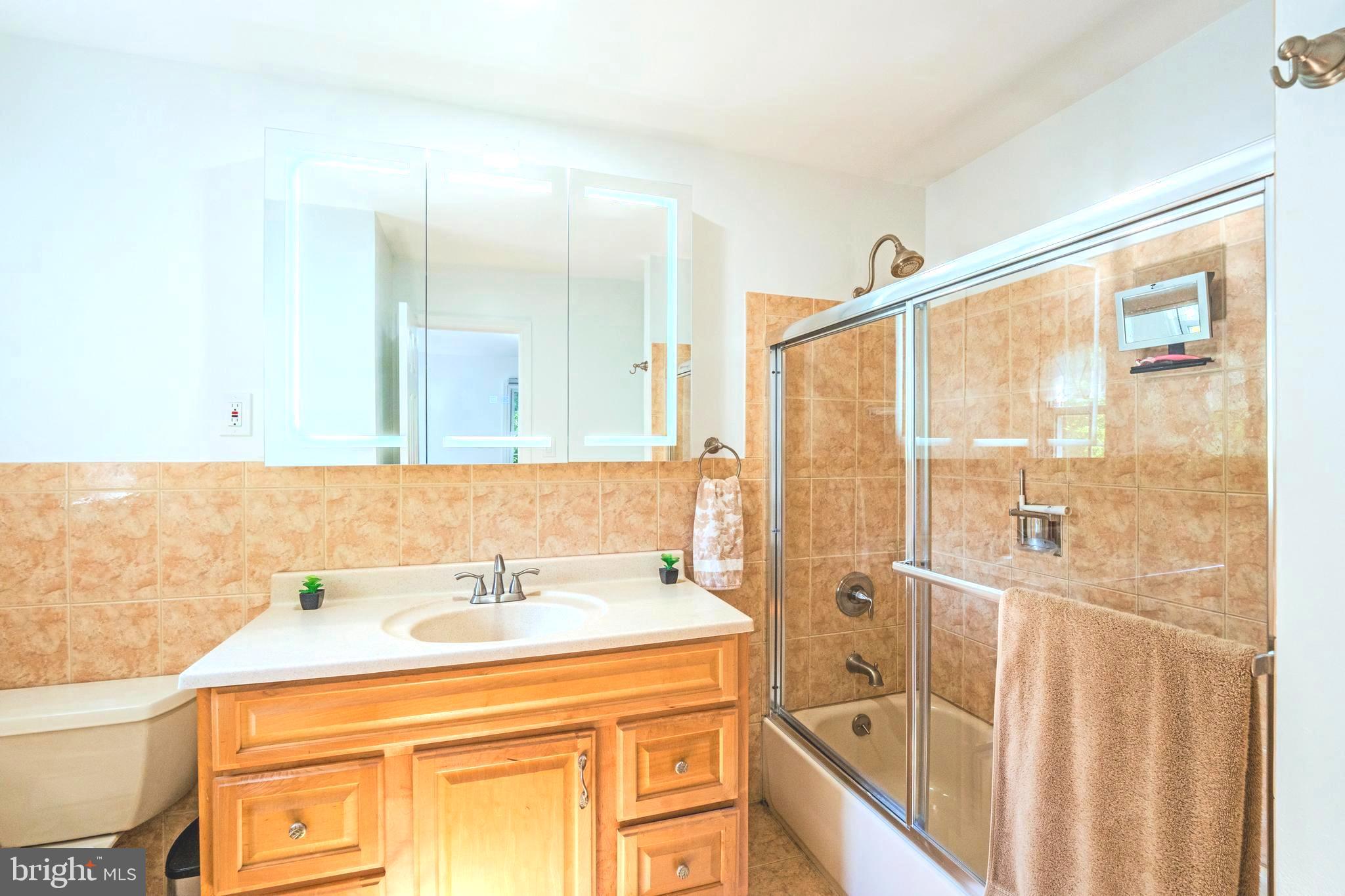 6705 Bracken Court Springfield, VA 22152 - Photo 21 of 40 a bathroom with a sink a mirror and a shower