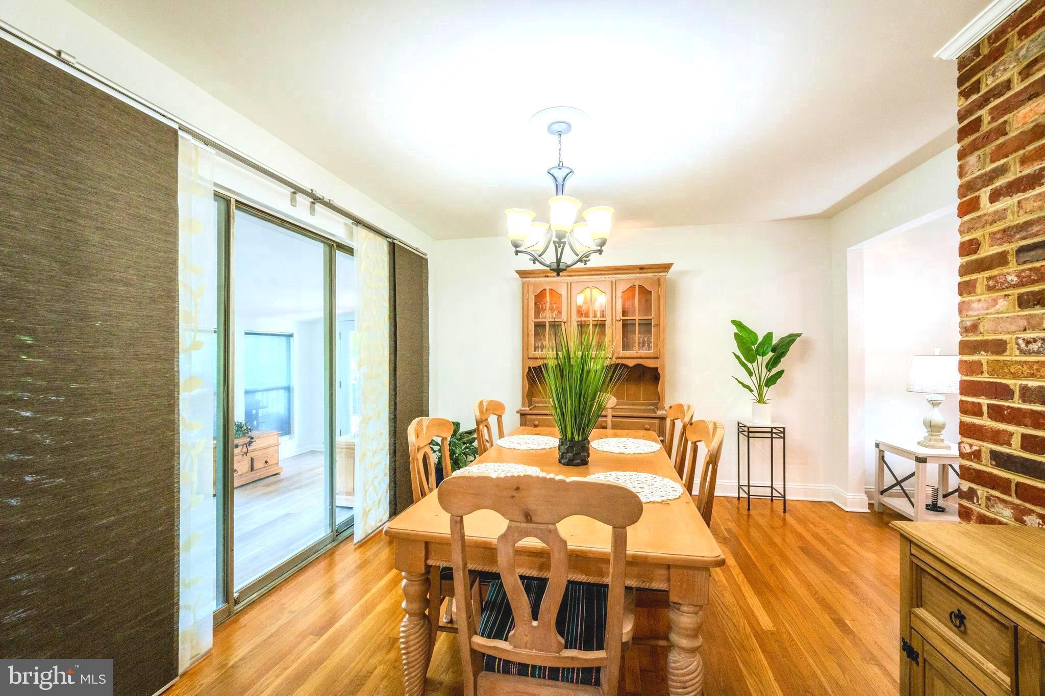 6705 Bracken Court Springfield, VA 22152 - Photo 10 of 40 a view of a dining room with furniture a potted plant and wooden floor