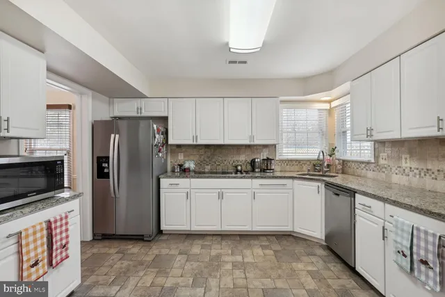 a kitchen with stainless steel appliances granite countertop a refrigerator sink and stove