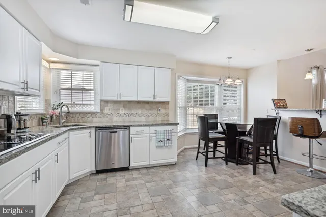 a kitchen with sink dining table and chairs