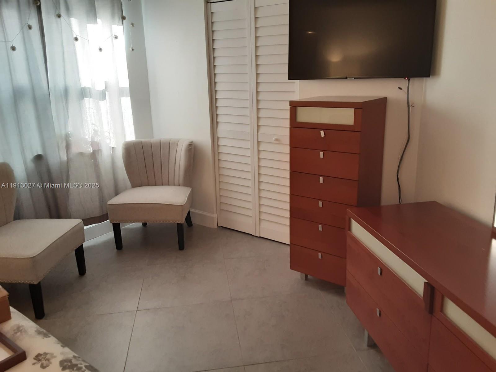 9409 Fontainebleau Boulevard, Unit 207 Miami, FL 33172 - Photo 14 of 19 a living room with furniture and a flat screen tv