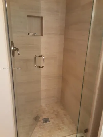 a bathroom with a glass door shower