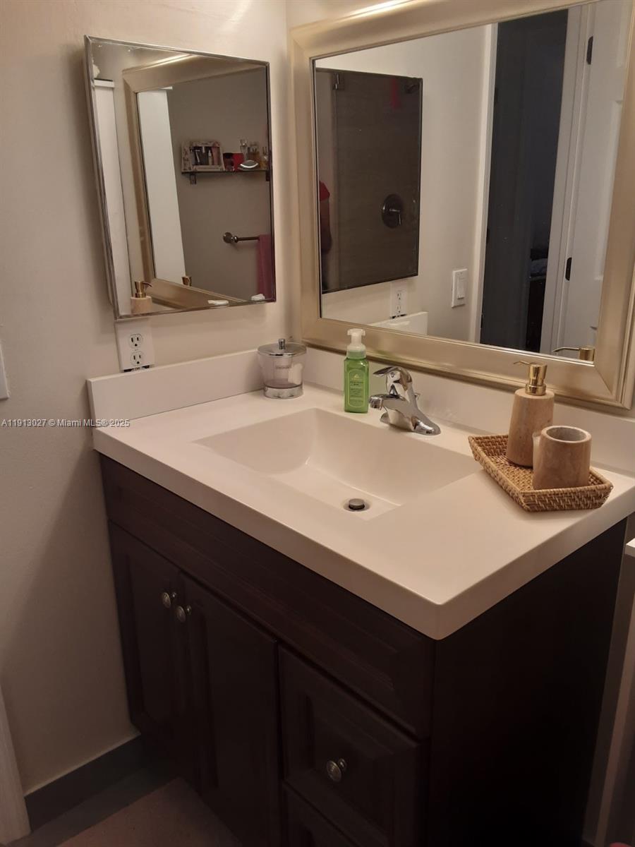 9409 Fontainebleau Boulevard, Unit 207 Miami, FL 33172 - Photo 16 of 19 a bathroom with a sink and a mirror