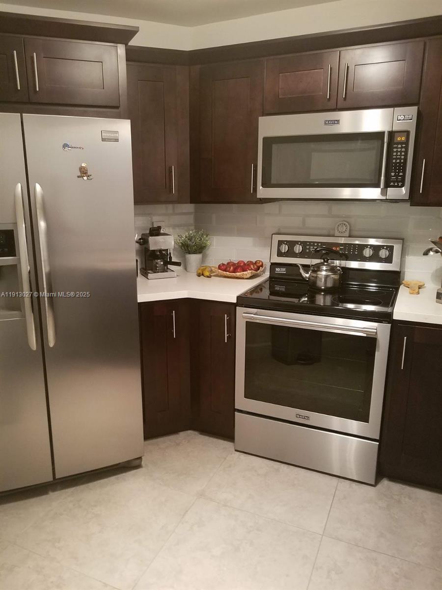 9409 Fontainebleau Boulevard, Unit 207 Miami, FL 33172 - Photo 6 of 19 a kitchen with a stove microwave and refrigerator