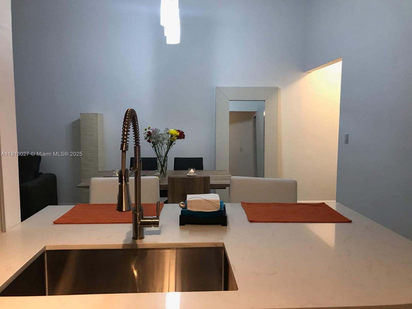 9409 Fontainebleau Boulevard, Unit 207 Miami, FL 33172 - Photo 7 of 19 a kitchen with a table chairs and a refrigerator