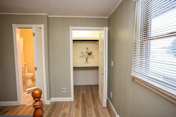a bedroom with a bed and a dresser next to a window