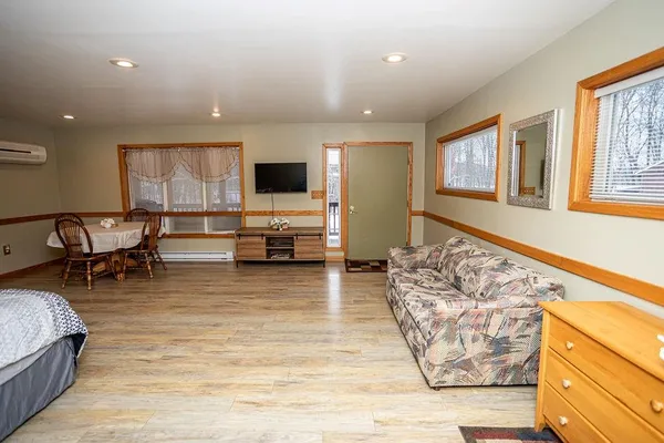 a spacious bedroom with a bed and wooden floor
