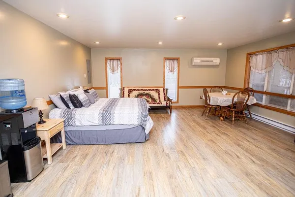 a spacious bedroom with a bed and wooden floor