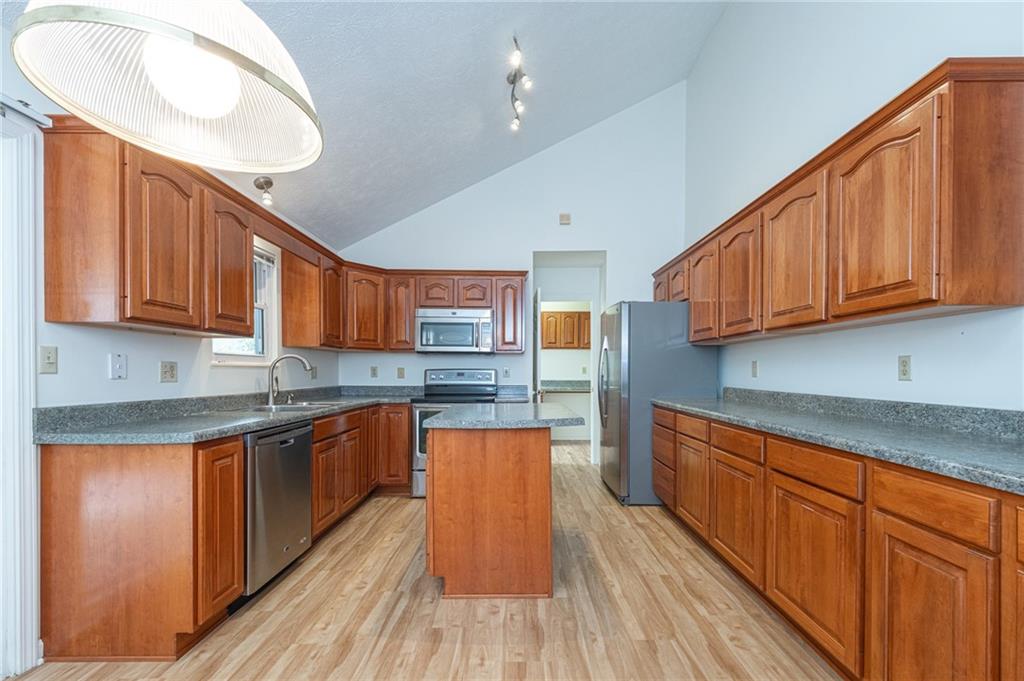 306 Georgetown Lane Export, PA 15632 - Photo 3 of 35 a kitchen with stainless steel appliances granite countertop wooden cabinets a stove a sink and dishwasher with wooden floor