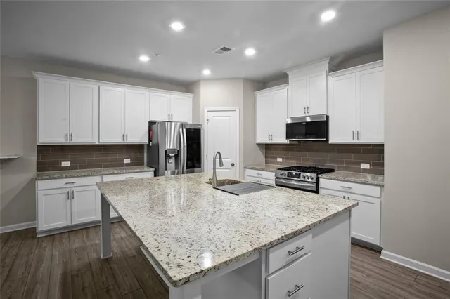 a kitchen with stainless steel appliances granite countertop a sink stove and refrigerator