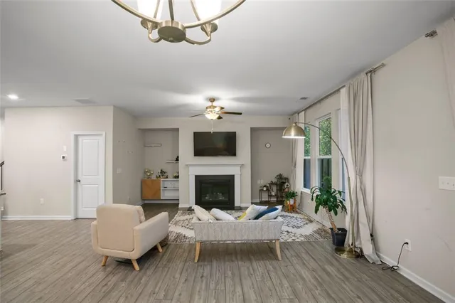 a living room with furniture a fireplace and a chandelier