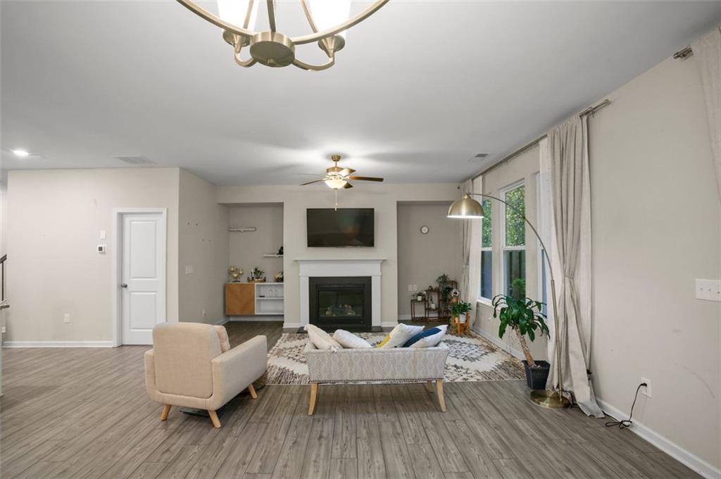 465 Duval Drive Alpharetta, GA 30009 - Photo 5 of 21 a living room with furniture a fireplace and a chandelier