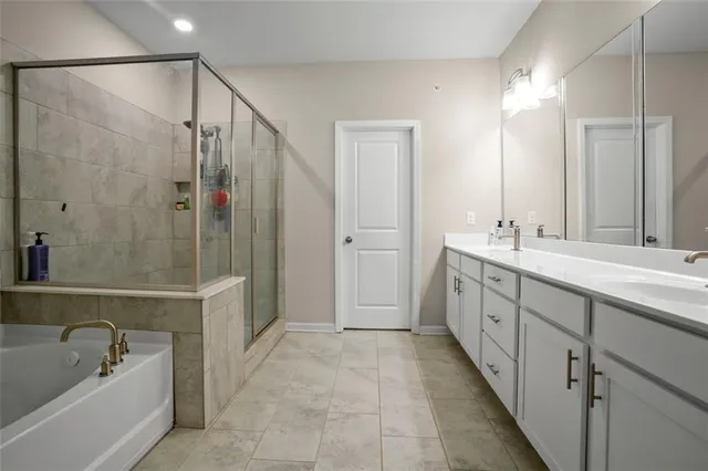 a spacious bathroom with a tub sink shower and mirror