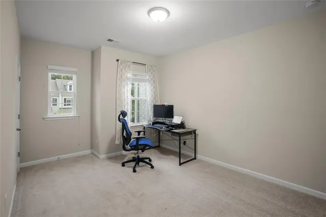 a view of a workspace with furniture and a window