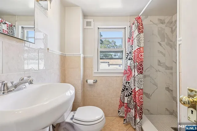 a white toilet sitting next to a white sink and tub