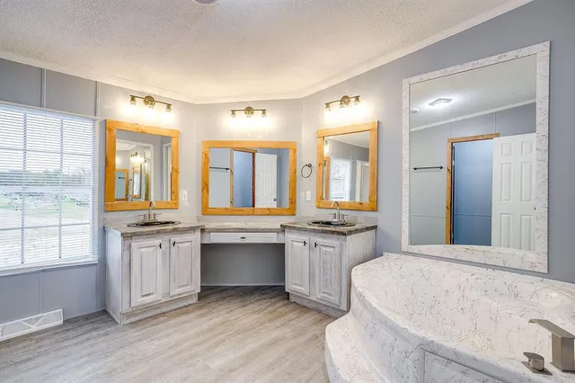 a spacious bathroom with a tub sink and mirror