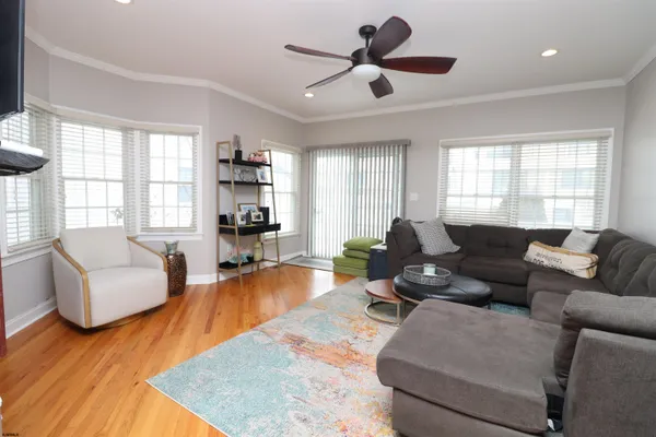 a living room with furniture and a flat screen tv with wooden floor